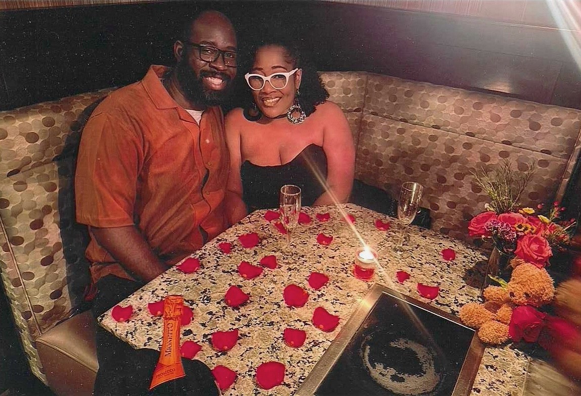 Boris and Marion at their engagement dinner with rose petals on the table